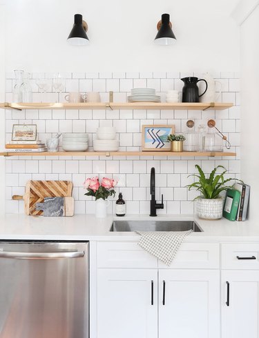 white kitchen with single bowl stainless steel sink and open shelving