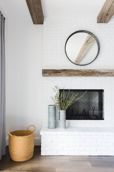 rustic living room idea with weathered mantel and exposed ceiling beams