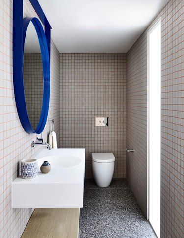 Coral grout on white tiles with electric blue mirror
