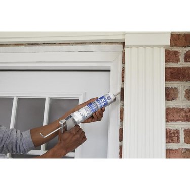 Caulking a door.