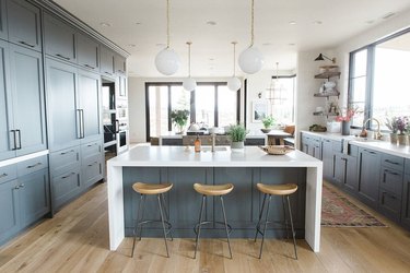 White waterfall countertop in blue kitchen by Studio McGee