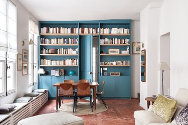 narrow apartment with terra-cotta floors and built-in bookcase