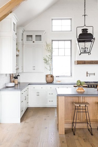 white kitchen with grey countertops and wood island