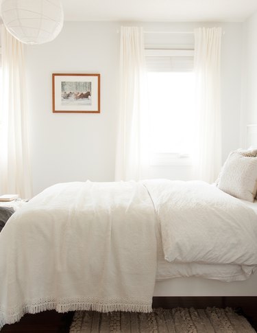 white bohemian bedroom with white curtains and linen