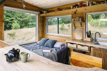 wood backsplash in a small kitchen in a cabin overlooking trees