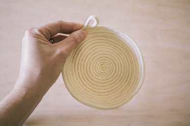 Tail of rope rolled into a loop shape and glued in place on the rim of the bowl