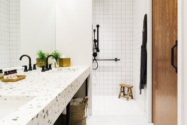 white minimalist shower with gridded square tiles and black fixtures