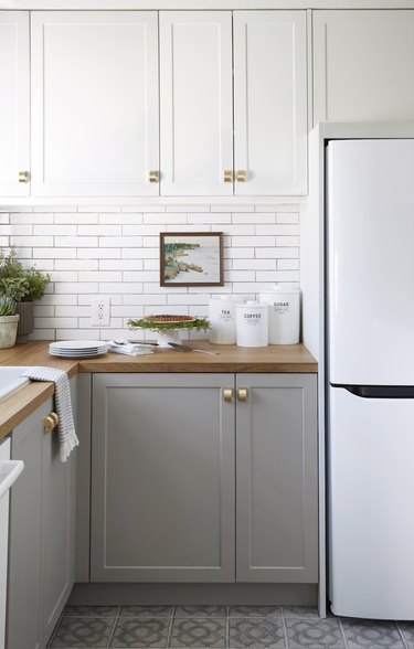 lower gray kitchen cabinets with upper white cabinets