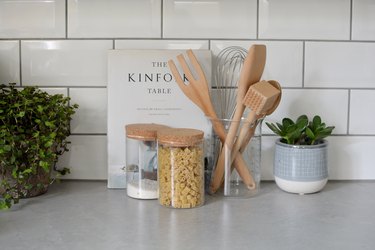 arrangement of jars on a kitchen countertop with subway tile background