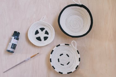 Three cotton rope bowls painted with black graphic patterns