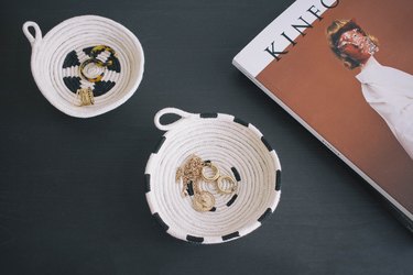 Two DIY painted cotton rope bowls on table with jewelry inside