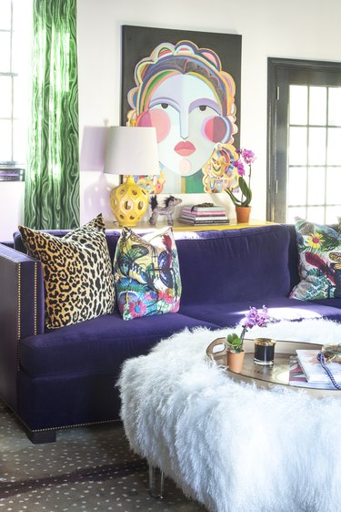 Hollywood Regency living room with purple velvet couch and abstract artwork