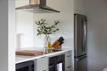 view of kitchen countertops with venting above and refrigerator