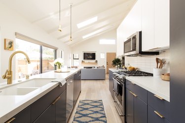 kitchen with dark grey cabinetry, white countertops, large sink, range and microwave