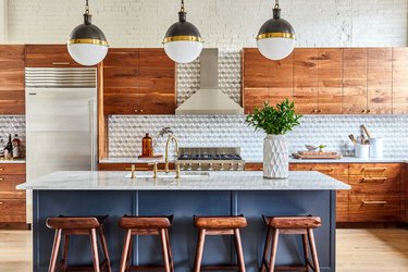 painted wood gray kitchen island with wooden stools and spherical pendant lights