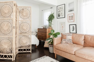 Boho apartment decor with rattan room divider and leather couch