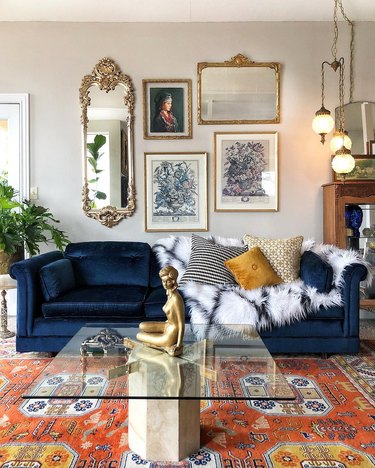 Hollywood Regency living room with gallery wall and blue velvet couch