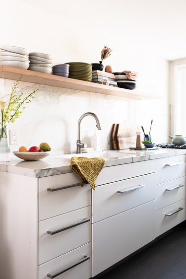 galley-style kitchen with light kitchen cabinets and sink