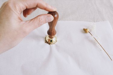 Pressing wax seal stamp into melted wax