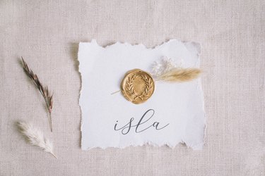 Gold wax seal and dried flowers glued to center of raw edged place card