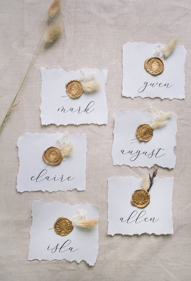 Six DIY gold wax seal place cards with dried flowers