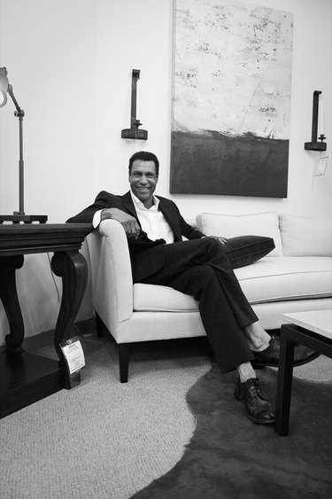 black and white photograph of designer darryl carter sitting on a couch