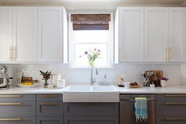 monochrome kitchen cabinets, farmhouse sink and window above sink