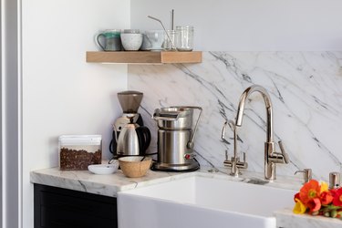 kitchen faucet with natural stone backsplash and farmhouse sink