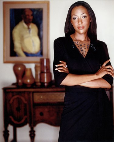 photograph of designer keita turner standing in interior featuring a painting and wood dresser