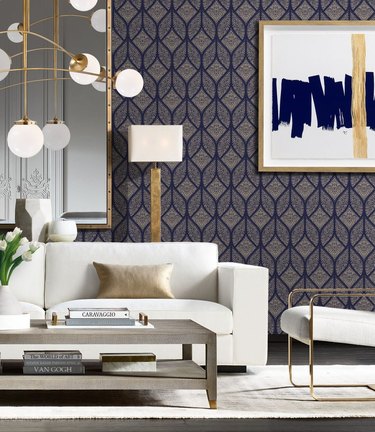 living room in art deco style with dark patterned wallpaper and white couch