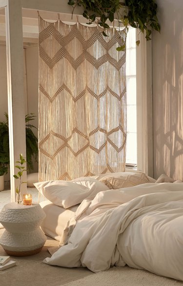 Macrame curtain in natural hanging in bedroom.
