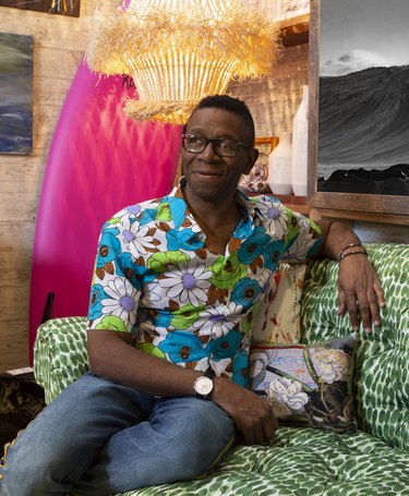 photograph of designer rayman boozer reclining on green patterned couch