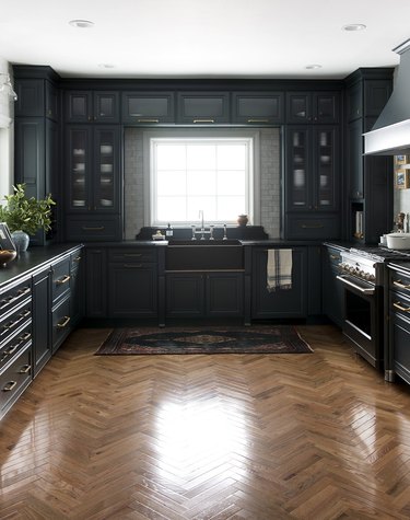 Hardwood herringbone modern kitchen flooring with navy blue cabinets