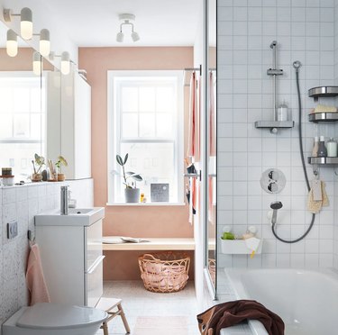 IKEA bathroom lighting idea with pink accent wall and white tile shower