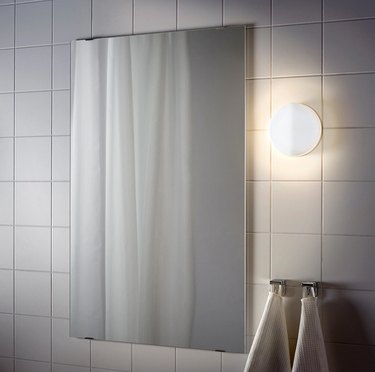 IKEA bathroom lighting idea with white tile wall and wall light