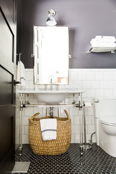 art deco bathroom by Studio McGee with black mosaic floor tile and console sink