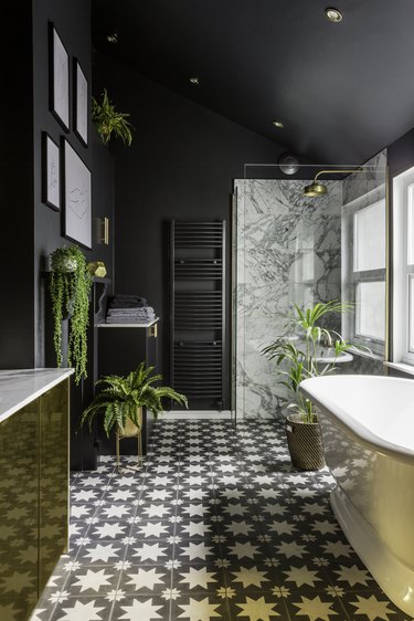 art deco bathroom by Gold Is a Neutral with black walls and patterned floor tile