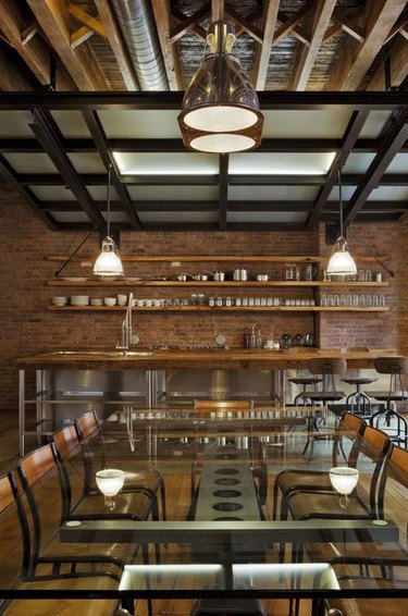 exposed beams in open concept room with stainless steel industrial kitchen island