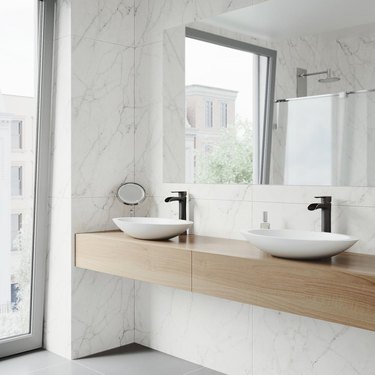 bathroom space with marble walls and two sinks