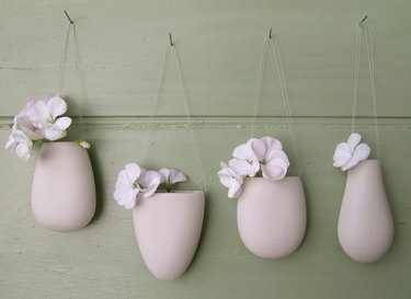 four white porcelain flower bud vessels that are decorative accents