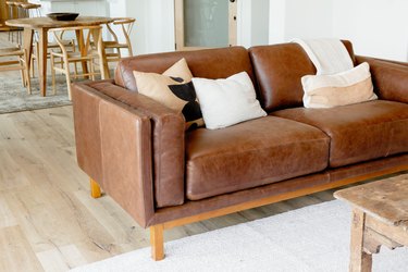 brown leather couch on light wood floor