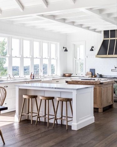 white farmhouse kitchen with white island and wooden island