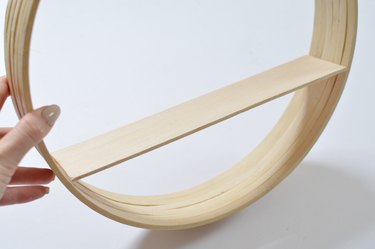 Wooden shelf placed inside circular frame