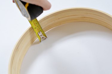 Tape measure extended to measure wooden hoops.