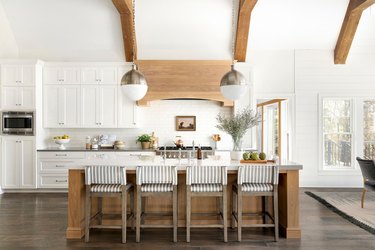 Dark wood farmhouse kitchen floor with white cabinets and exposed ceiling beams