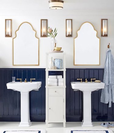 Brass and white coastal bathroom lighting idea with accompanying wall sconces in white and navy blue bathroom