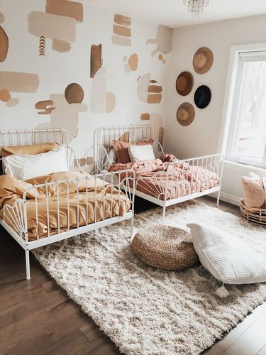 boho girls room with matching twin beds and decals on wall