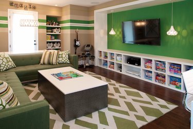 family room ideas with TV mounted on green wall with built in cubbies