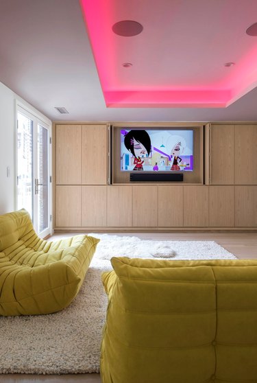 minimal family room ideas with TV and pink overhead lighting