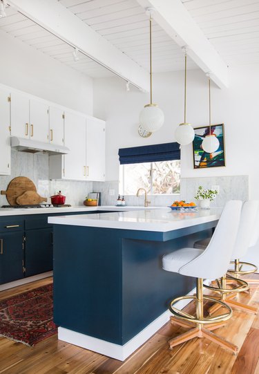 Blue and gray kitchen with midcentury details and globe-style pendant lights